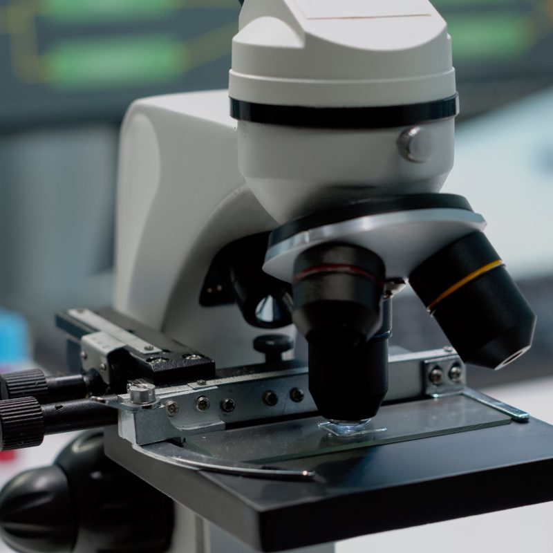 Close up of glass lens microscope on laboratory desk